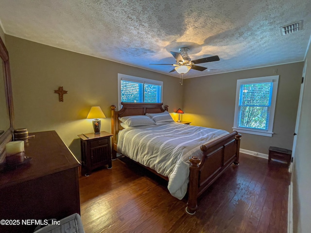 bedroom featuring ceiling fan, dark wood-type flooring, and multiple windows