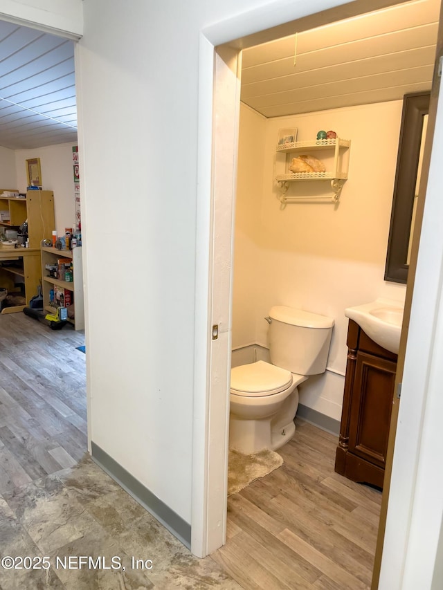 bathroom featuring vanity, toilet, and wood-type flooring