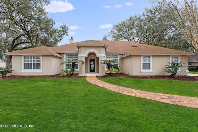 view of front of home featuring a chimney, a front lawn, and stucco siding