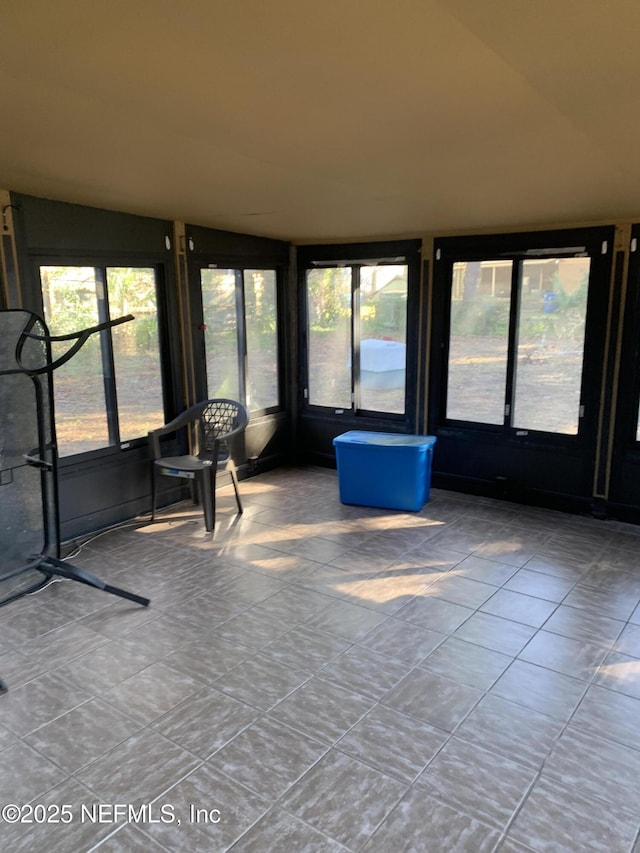 unfurnished sunroom featuring vaulted ceiling