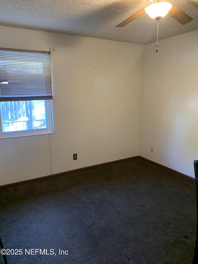 carpeted spare room with ceiling fan and a textured ceiling