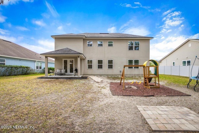 back of property featuring a playground, a patio area, and a yard