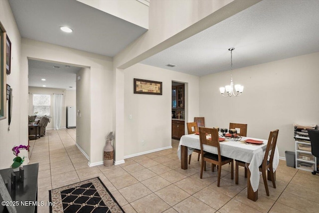 tiled dining space with a chandelier