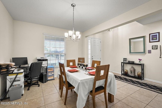 tiled dining space with a textured ceiling and a chandelier