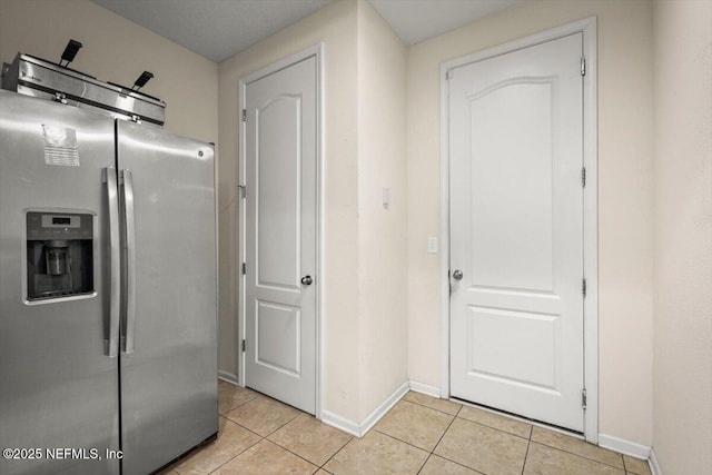 kitchen featuring stainless steel fridge with ice dispenser and light tile patterned flooring