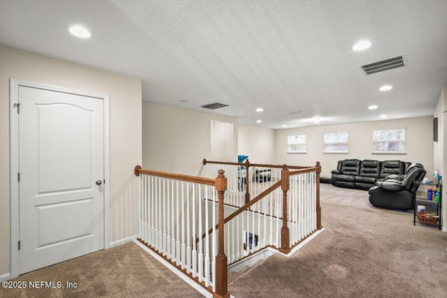 hallway featuring light colored carpet