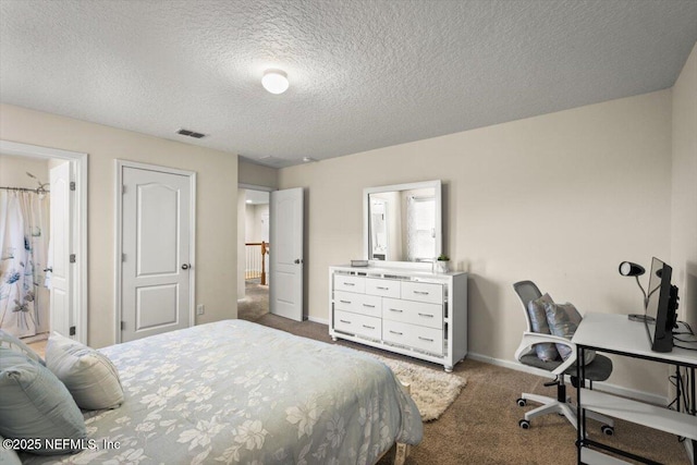 carpeted bedroom with a textured ceiling and connected bathroom