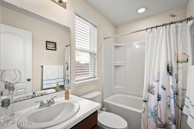 full bathroom with vanity, toilet, shower / bath combo with shower curtain, and a textured ceiling