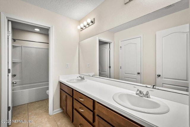 full bathroom with vanity, washtub / shower combination, tile patterned flooring, toilet, and a textured ceiling