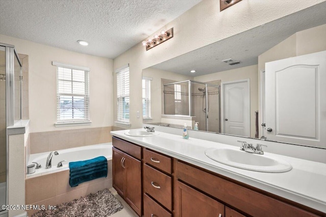 bathroom featuring vanity, a textured ceiling, and plus walk in shower