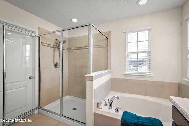 bathroom with tile patterned floors, vanity, a textured ceiling, and independent shower and bath