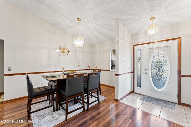 entrance foyer with an inviting chandelier, a textured ceiling, and wood-type flooring