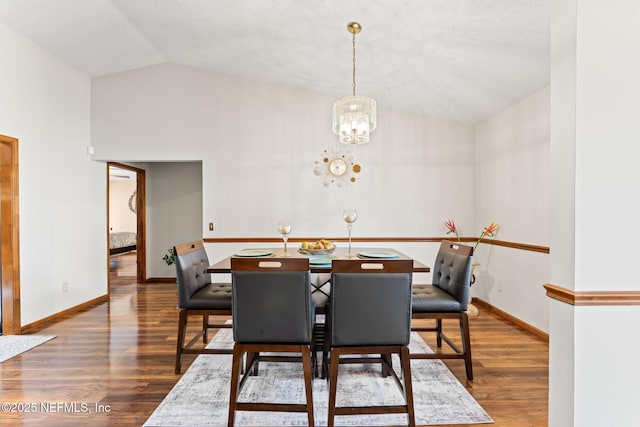 dining area featuring a chandelier, vaulted ceiling, and dark wood-type flooring