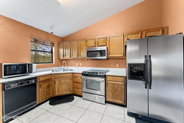 kitchen featuring appliances with stainless steel finishes, a textured ceiling, lofted ceiling, sink, and light tile patterned flooring