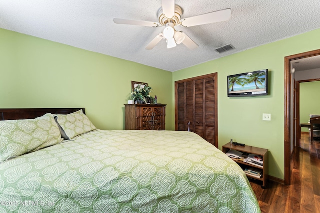 bedroom with ceiling fan, dark wood-type flooring, a closet, and a textured ceiling