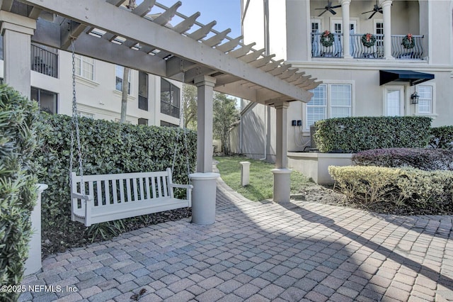 view of patio featuring ceiling fan, a balcony, and a pergola