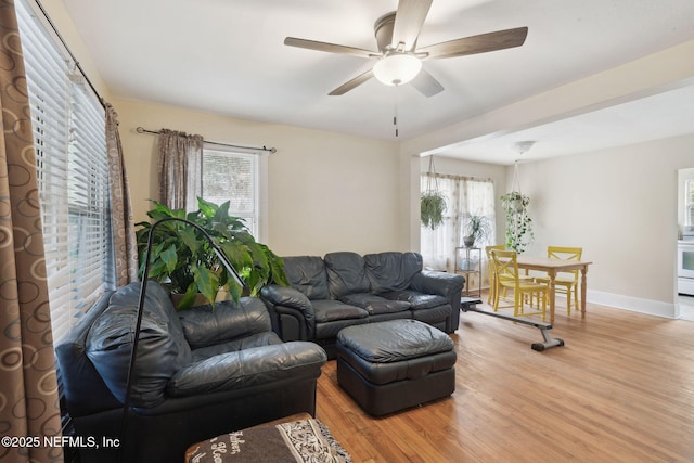 living room featuring light hardwood / wood-style floors and ceiling fan