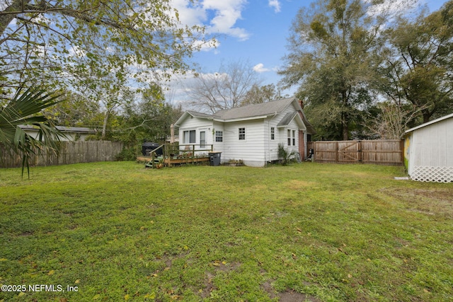 rear view of property with a lawn and a wooden deck