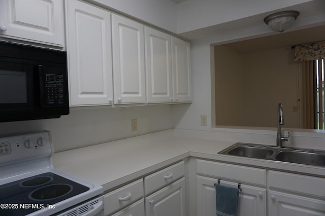 kitchen featuring white electric range oven, white cabinetry, and sink