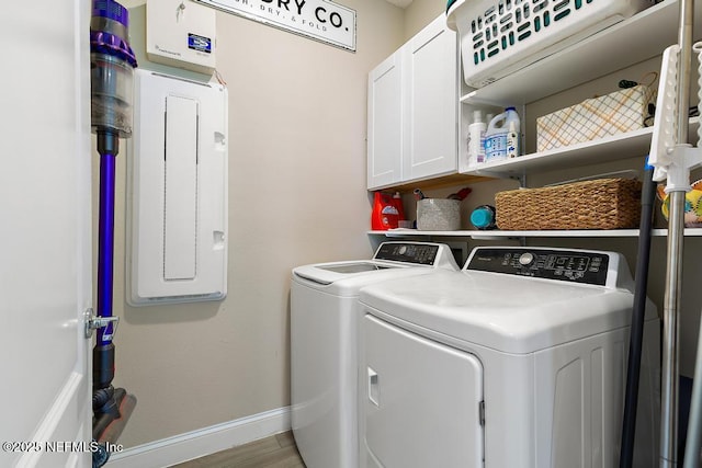 clothes washing area with washer and dryer, cabinet space, baseboards, and wood finished floors