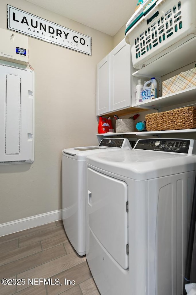 laundry room featuring separate washer and dryer and cabinets