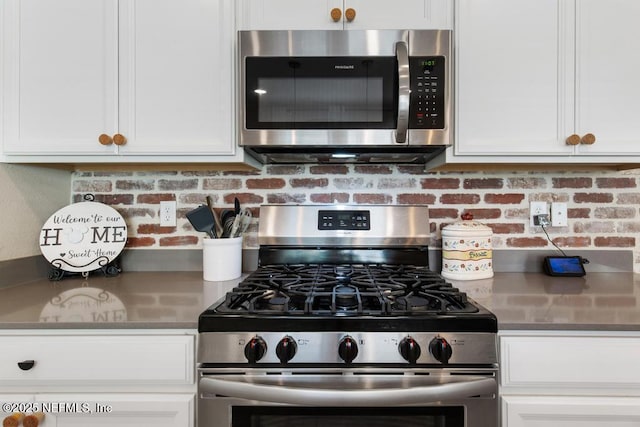 kitchen featuring backsplash, white cabinets, and stainless steel appliances