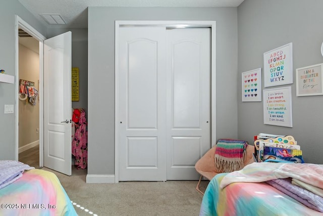 bedroom featuring light carpet and a closet