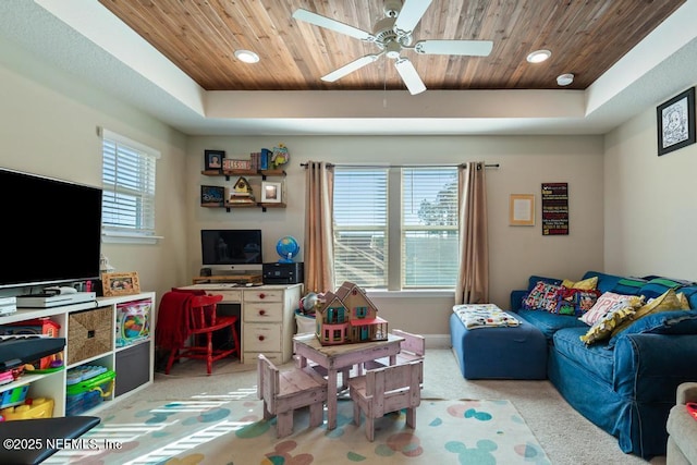 playroom with a tray ceiling, ceiling fan, wooden ceiling, and light colored carpet