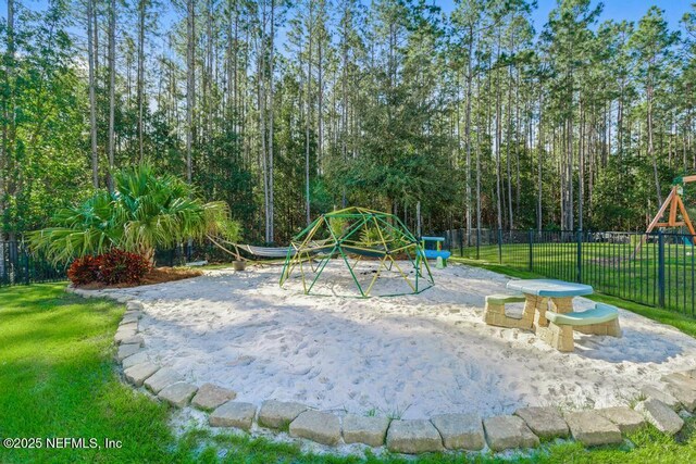 community playground featuring a yard, volleyball court, and fence