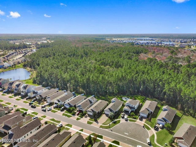 birds eye view of property with a residential view, a water view, and a view of trees