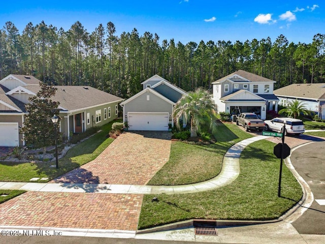 view of front facade with a garage, a front lawn, and decorative driveway