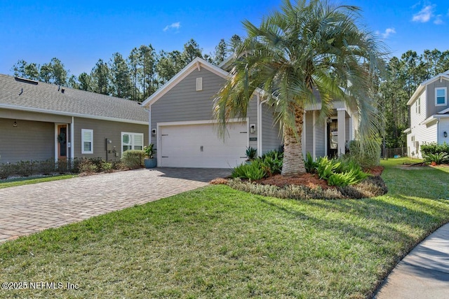 view of front of property featuring a garage, a front lawn, and decorative driveway