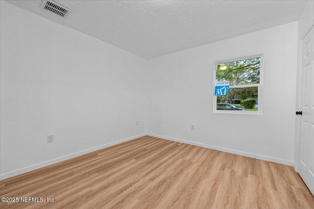 unfurnished room with a textured ceiling and light hardwood / wood-style floors