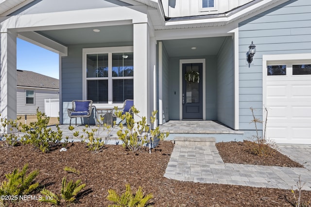 property entrance with covered porch and a garage