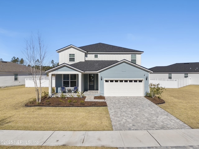 view of front of home with a garage, a porch, and a front yard