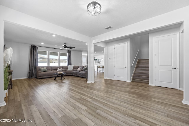 unfurnished living room featuring ceiling fan, a textured ceiling, and light hardwood / wood-style flooring