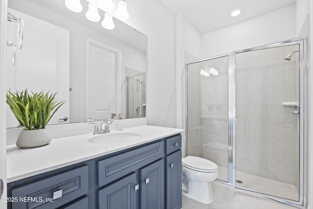 bathroom featuring toilet, vanity, tile patterned floors, and a shower with shower door