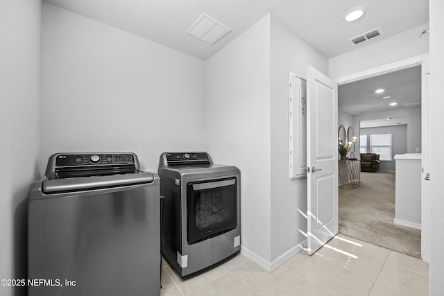 clothes washing area featuring light colored carpet and independent washer and dryer