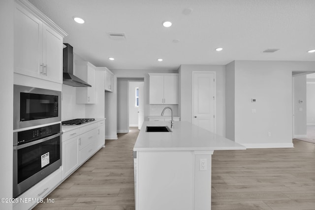 374 Sutton Dr, Ponte Vedra, FL 32081 - kitchen featuring stainless steel oven, wall chimney exhaust hood, built in microwave, gas stovetop, and light wood finished floors