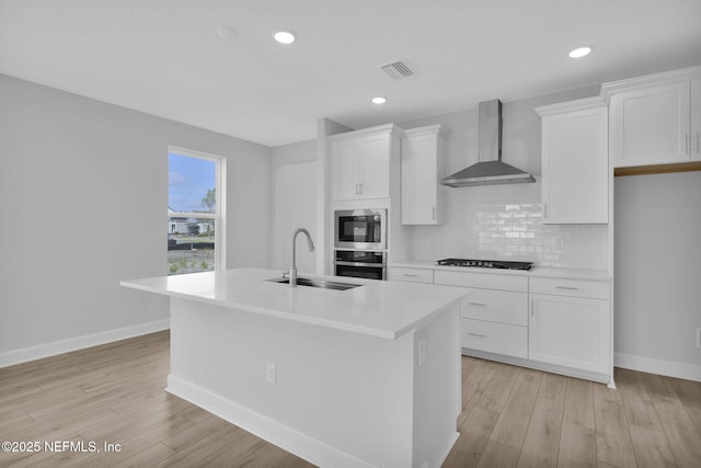 374 Sutton Dr, Ponte Vedra, FL 32081 - kitchen with wall chimney exhaust hood, stainless steel appliances, a center island with sink, white cabinets, and light countertops