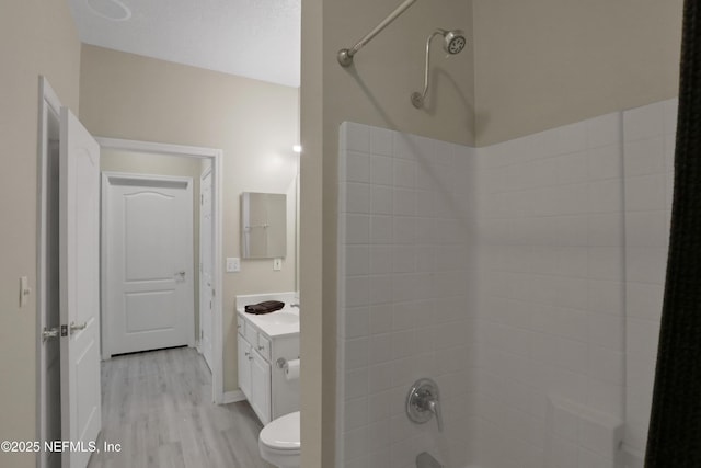 full bathroom featuring shower / washtub combination, vanity, wood-type flooring, and toilet