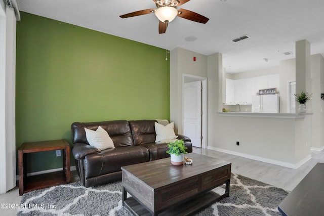 living room featuring hardwood / wood-style floors and ceiling fan