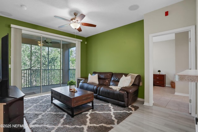 living room with light hardwood / wood-style flooring and ceiling fan