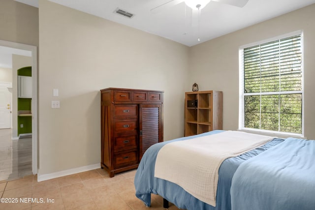 tiled bedroom featuring ceiling fan