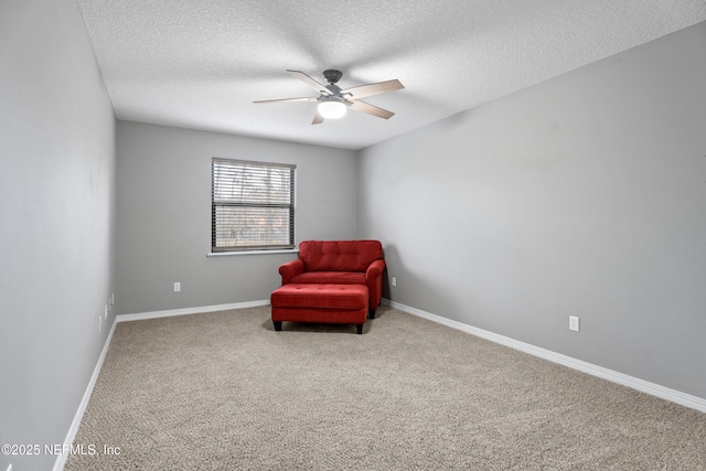 sitting room featuring a textured ceiling, carpet floors, and ceiling fan