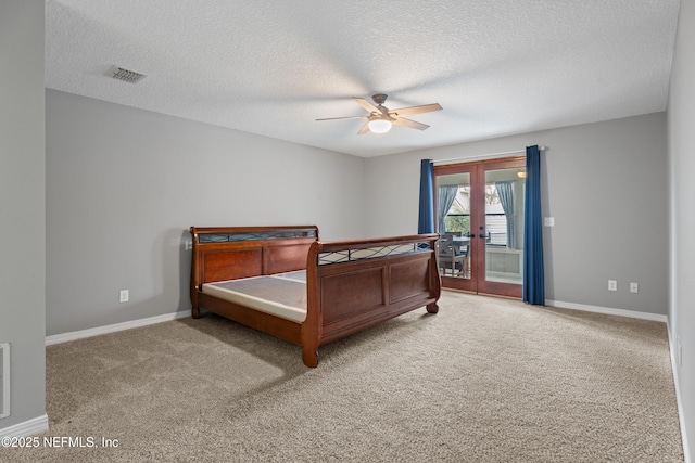 carpeted bedroom featuring ceiling fan, french doors, and a textured ceiling