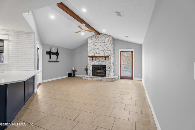 unfurnished living room featuring ceiling fan, light tile patterned flooring, vaulted ceiling with beams, and a fireplace