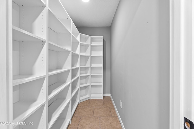 spacious closet with light tile patterned floors