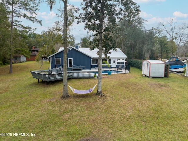 view of yard featuring a pool side deck and a shed