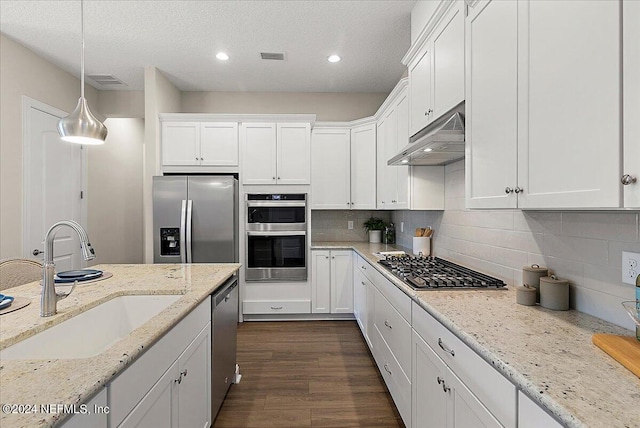 kitchen with pendant lighting, sink, stainless steel appliances, and white cabinets